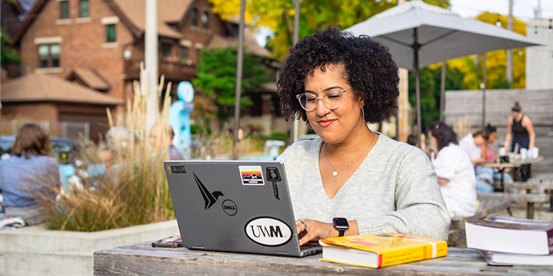 UWM online MSW student studying at a cafe